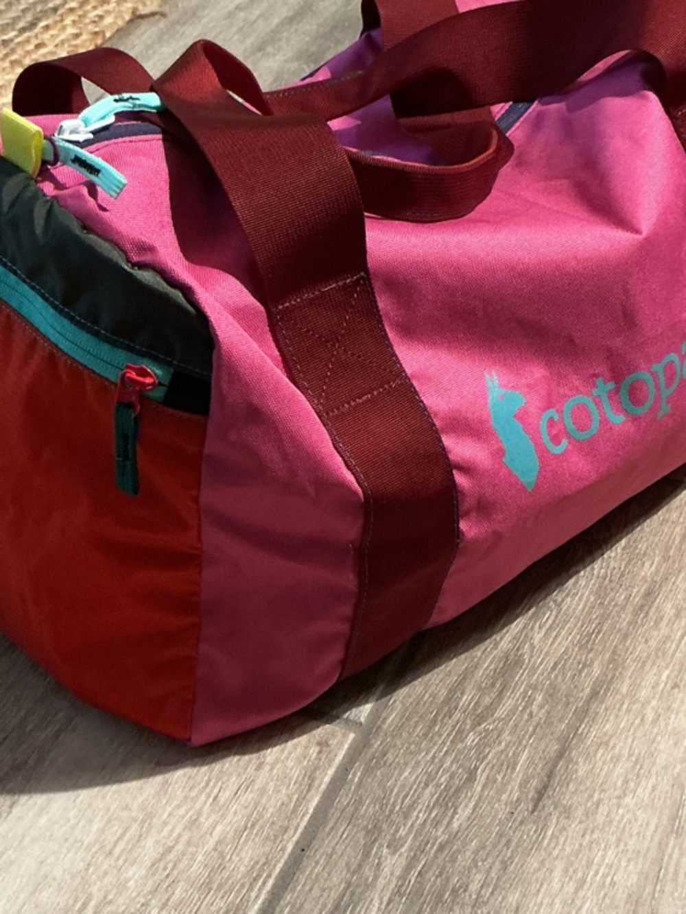 cotopaxi Pink and Red Travel Duffel with Teal Logo